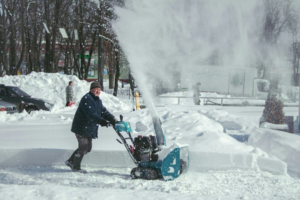 Man operating snow blower during snowfall